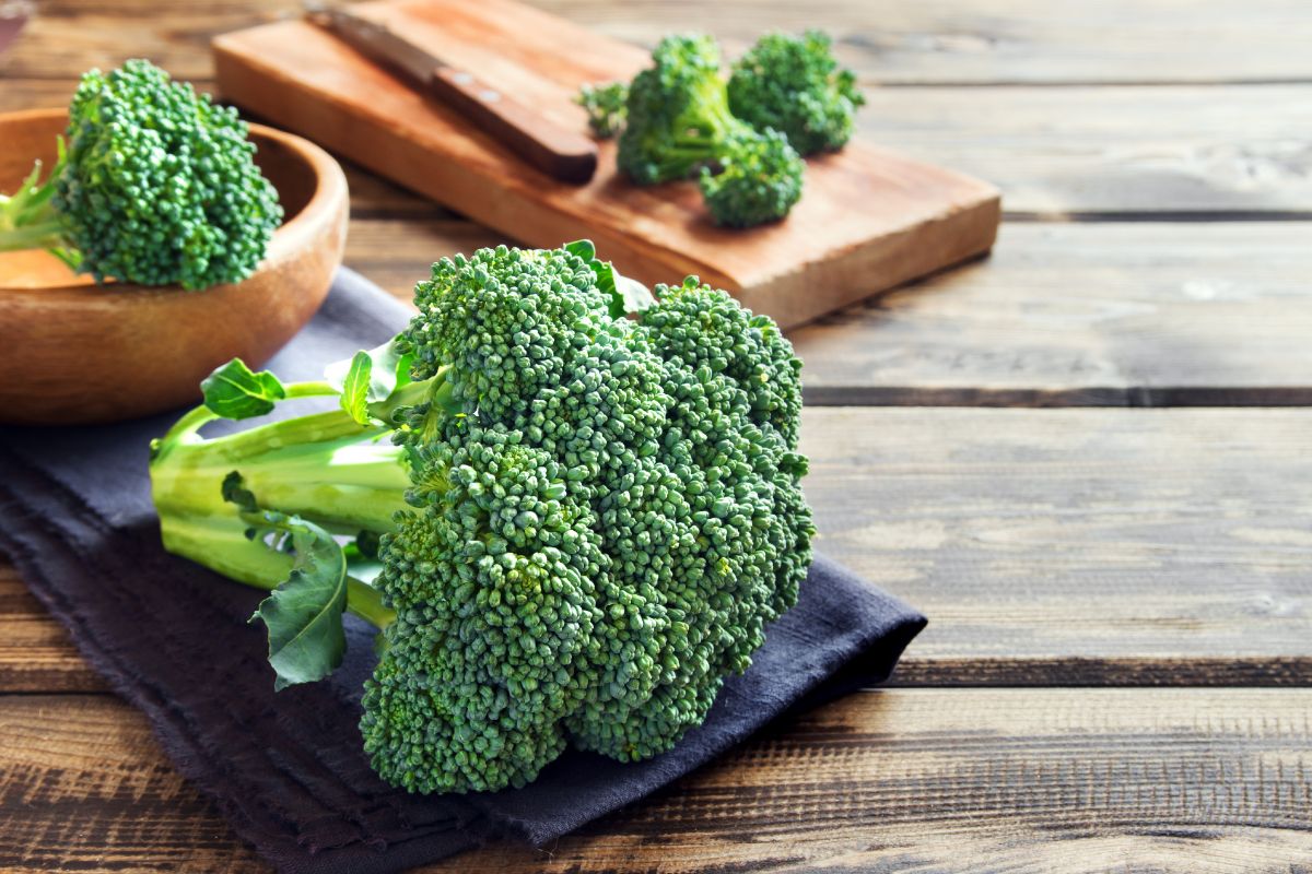 Raw organic broccoli on a wooden table.